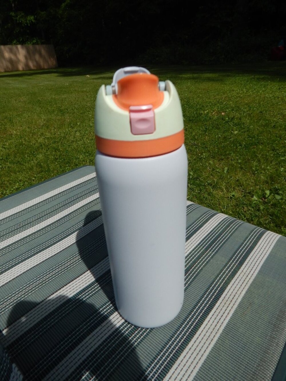 Owala water bottle, grey, orange, yellow and pink.